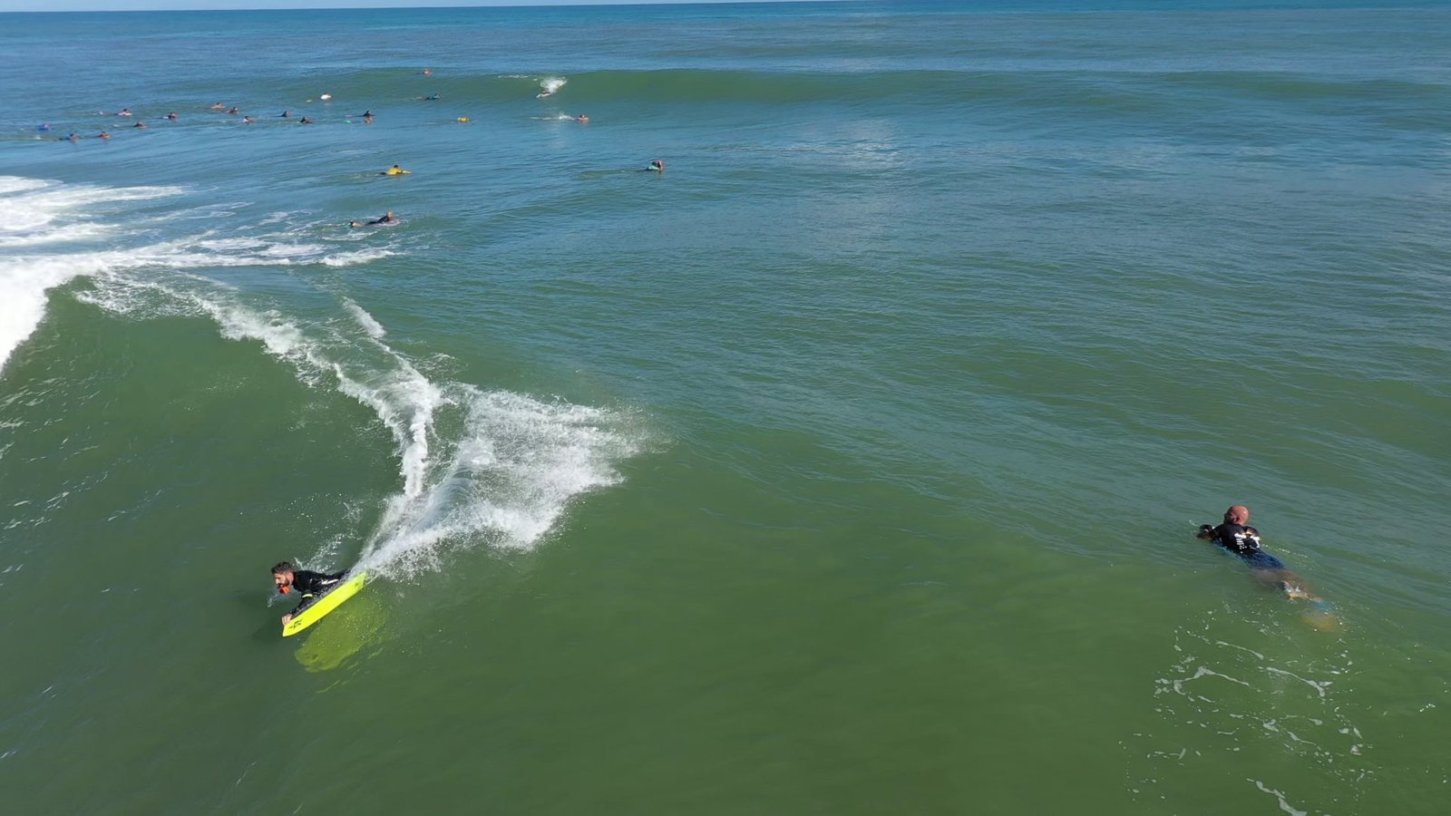 Aerial view of a bodyboarder riding a wave on a yellow board