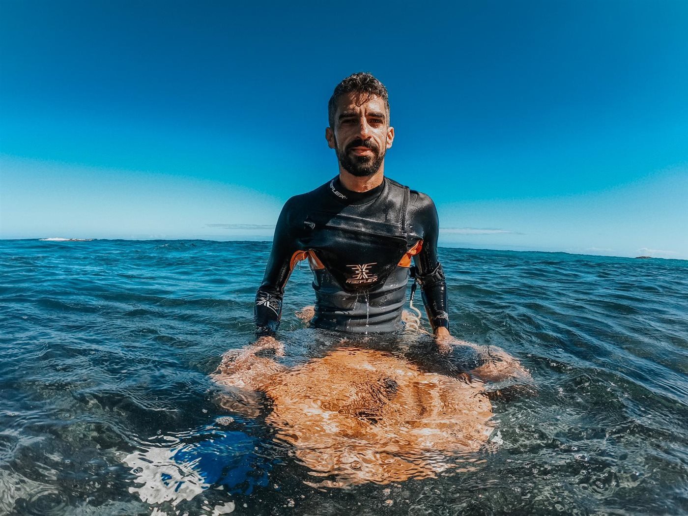 Portrait of a bodyboarder with his board in the ocean